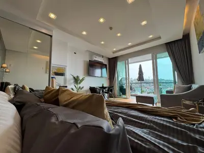 a hotel room with a bed and a large window at Luxury Seaview studio apartment at Karon beach in Karon Beach