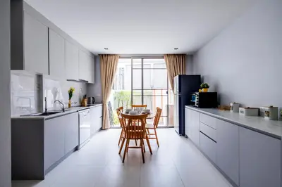 a kitchen with white cabinets and a table and chairs at SPACIOUS AND BRIGHT 2BR TownHouse7 MonkeyHill in Ban Sam Kong