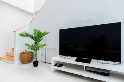 a living room with a large flat screen tv at SPACIOUS AND BRIGHT 2BR TownHouse7 MonkeyHill in Ban Sam Kong