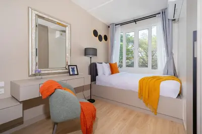 a bedroom with a bed and a mirror and a chair at Patong private pool Villa 5BR 4Bath in Patong Beach