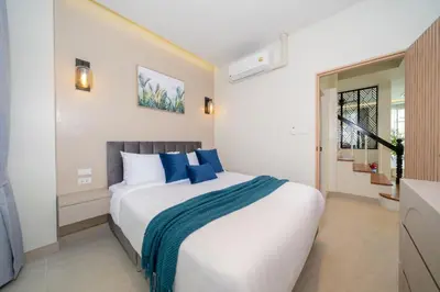 a bedroom with a large white bed with blue pillows at Patong private pool Villa 5BR 4Bath in Patong Beach