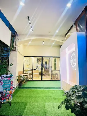 a building with a lobby with green grass at Dedbaicha cafe & Hostel Phuket old town in Phuket Town