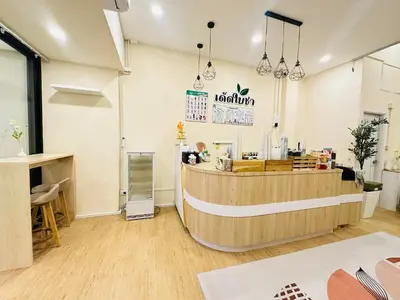 a restaurant with a counter in a room at Dedbaicha cafe & Hostel Phuket old town in Phuket Town