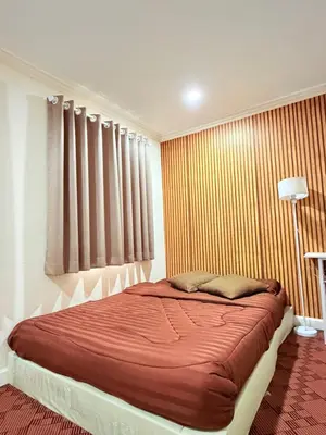 a bedroom with a bed with red sheets and curtains at Dedbaicha cafe & Hostel Phuket old town in Phuket Town