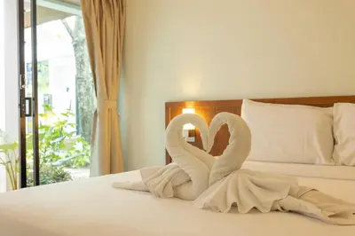 two white swans sitting on top of a bed at V172 Siena Villa Stunning 3-Bedroom & Private Pool in Kata Beach