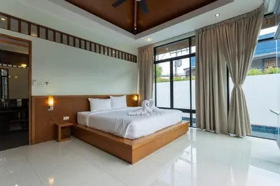 a bedroom with a bed and a large window at V172 Siena Villa Stunning 3-Bedroom & Private Pool in Kata Beach