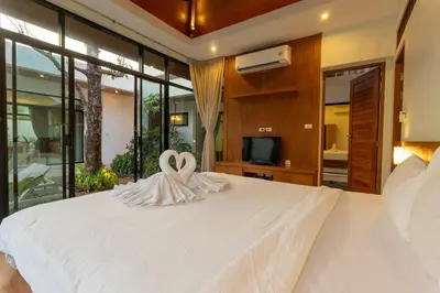 two white swans sitting on top of a bed at V172 Siena Villa Stunning 3-Bedroom & Private Pool in Kata Beach