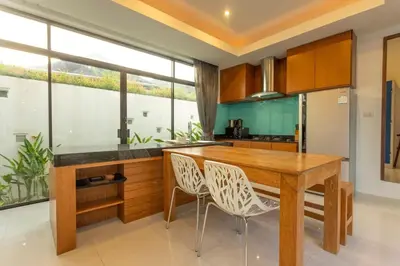 a kitchen with a wooden table and two chairs at V172 Siena Villa Stunning 3-Bedroom & Private Pool in Kata Beach