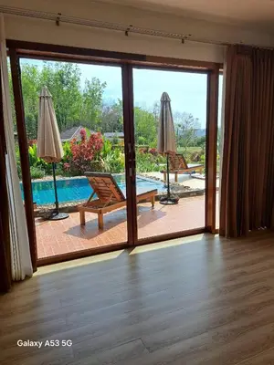 an open door to a patio with a view of a pool at Bulan Villa Koh Yao Noi in Ban Laem Sai