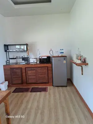 a kitchen with a stainless steel refrigerator and wooden cabinets at Bulan Villa Koh Yao Noi in Ban Laem Sai