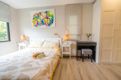 a bedroom with a bed and a desk in it at Lovely Vlada in Nai Yang Beach