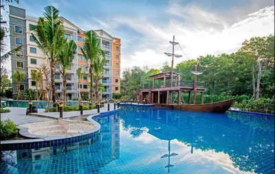 a large swimming pool with a boat in front of a building at Lovely Vlada in Nai Yang Beach