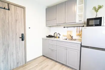 a kitchen with white cabinets and a refrigerator at Lovely Vlada in Nai Yang Beach