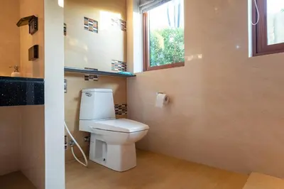 a bathroom with a white toilet and a window at 29 - Modern Pool Villa between Naiharn & Rawai in Ban Saiyuan (1)