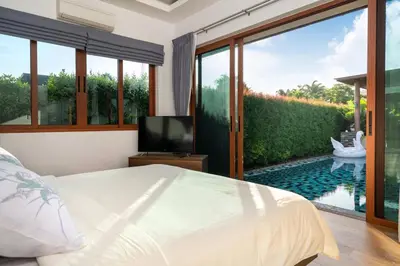 a bedroom with a bed and a view of a pool at 29 - Modern Pool Villa between Naiharn & Rawai in Ban Saiyuan (1)