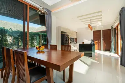 a kitchen and dining room with a wooden table and chairs at 29 - Modern Pool Villa between Naiharn & Rawai in Ban Saiyuan (1)
