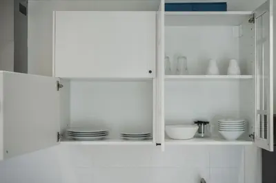 a white cabinet with plates and dishes in it at Квартира в The Title Halo 1 in Nai Yang Beach