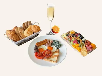 a table with a plate of breakfast food and a glass of champagne at Two bedrooms Penthouse Seaview Rawai Beach Phuket in Phuket Town