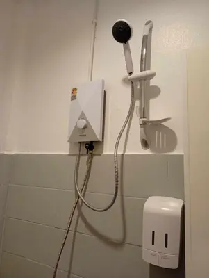 a bathroom with a blow dryer on a wall at Go To Party Hostel and Bar Aonang in Ao Nang Beach