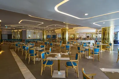 a dining room with tables and blue chairs at Super 2Bdr Apartament La Vita Rawai Naiharn beach in Rawai Beach