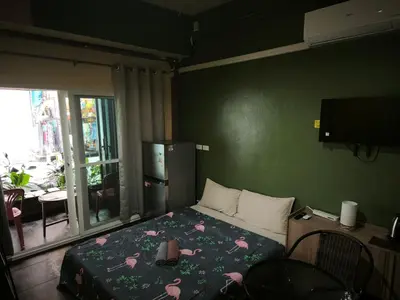a bedroom with a bed with flowers on it at Bonanza Patong Beach2 100m to Beach Green Room in Patong Beach