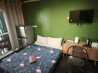 a small bedroom with a bed with pink flamingos on it at Bonanza Patong Beach2 100m to Beach Green Room in Patong Beach