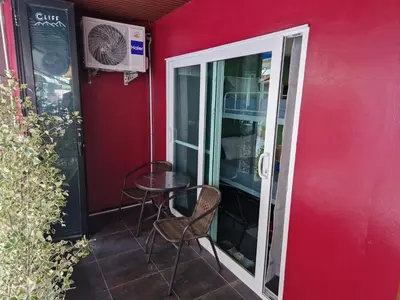 a room with a table and chairs and a red wall at Bonanza Patong Beach2 100m to Beach Green Room in Patong Beach