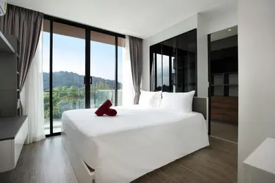 a bedroom with a large white bed and large windows at Elegant Natural Stay at VV Patong Apartment A401 in Patong Beach