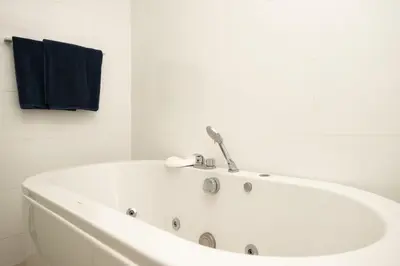 a white bath tub in a bathroom with a blue towel at Elegant Natural Stay at VV Patong Apartment A401 in Patong Beach