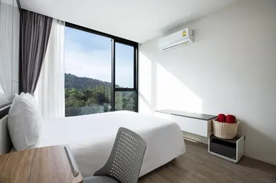 a hotel room with a bed and a window at Elegant Natural Stay at VV Patong Apartment A401 in Patong Beach