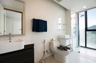 a bathroom with a toilet and a sink and a mirror at Elegant Natural Stay at VV Patong Apartment A401 in Patong Beach