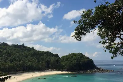 a beach with two boats in the water at Elegant Natural Stay at VV Patong Apartment A401 in Patong Beach