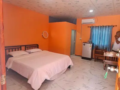 a bedroom with orange walls and a bed in it at Fadel Residence in Ko Yao Yai