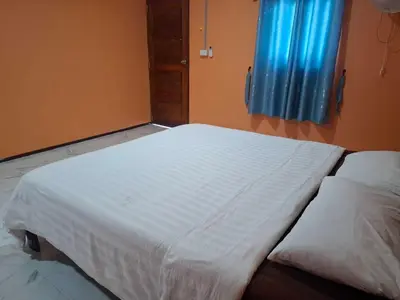 a bedroom with two beds with white sheets at Fadel Residence in Ko Yao Yai