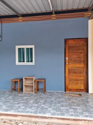 a blue wall with a wooden door and two tables at Fadel Residence in Ko Yao Yai