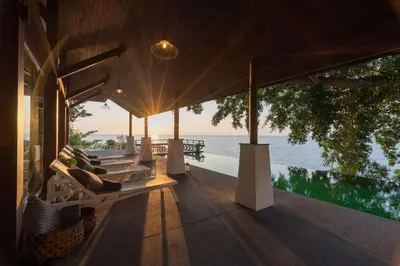 a porch of a house with a view of the water at 33 - The Cove in Laem Singh Beach in Surin Beach