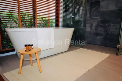 a bathroom with a bath tub and a stool at Villa M18 in Ban Pak Lak