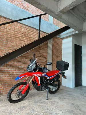 a red motorcycle parked next to a brick wall at Sky Lofts Airport Phuket in Nai Yang Beach