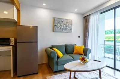 a living room with a couch and a table at Family 2 Bdr Suite in La Vita Rawai in Rawai Beach