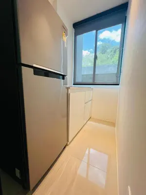 a kitchen with a refrigerator and a window at Utopia Kathu Condo in Phuket Town