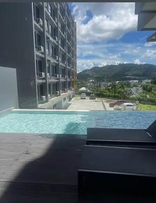 a swimming pool with a view of a building at Utopia Kathu Condo in Phuket Town