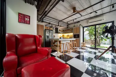 a living room with a red chair and a table at Luxury KING 3 BR, Gym, Sauna, BBQ, AirCon, 8 min Beach, Tennis Court, Boating Ave in Ban Pak Lak