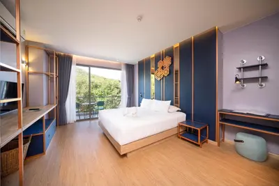 a bedroom with a white bed and a blue wall at The Blue Hotel in Chalong