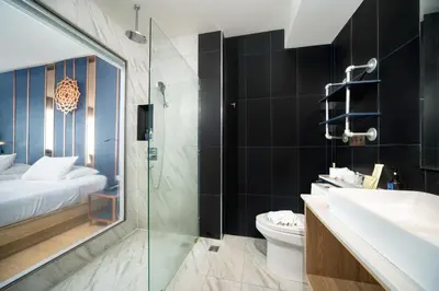 a bathroom with a sink and a toilet and a shower at The Blue Hotel in Chalong