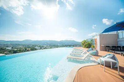 a swimming pool with lounge chairs on top of a building at The Blue Hotel in Chalong