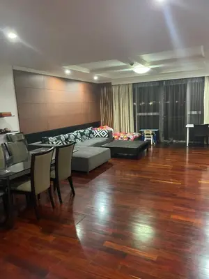 a living room with a couch and a table and chairs at Royal Apart Residence in Phuket Town