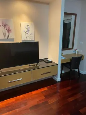 a living room with a flat screen tv on a dresser at Royal Apart Residence in Phuket Town
