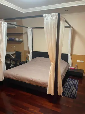 a bedroom with a bed with curtains and a desk at Royal Apart Residence in Phuket Town