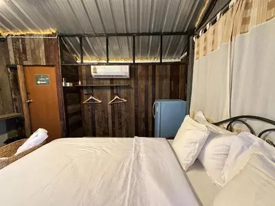 a bedroom with a bed and hangers in it at Cashew Garden House in Chalong