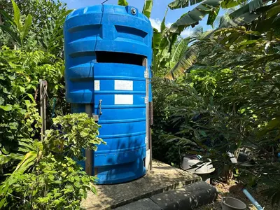 a blue iguana house sitting in a garden at Cashew Garden House in Chalong
